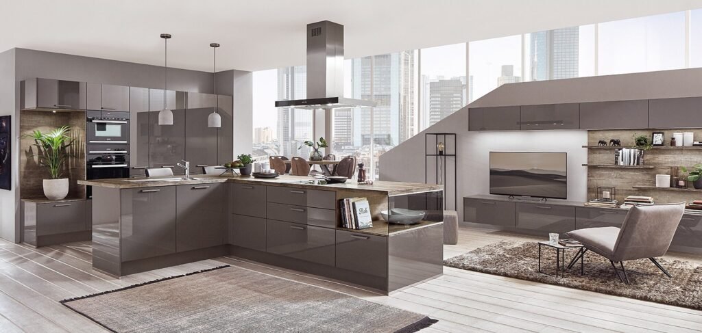 Cocina abierta al salón en Sevilla con acabados gris brillo, isla funcional y distribución contemporánea ideal para espacios urbanos.
