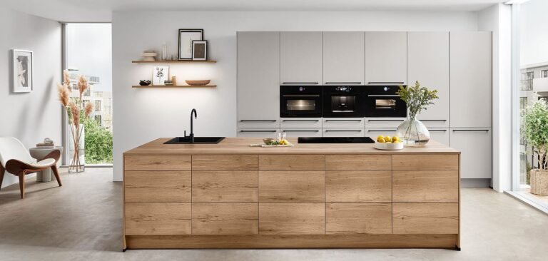 Cocina moderna en Sevilla con isla de madera, muebles blancos y electrodomésticos empotrados de alta gama.