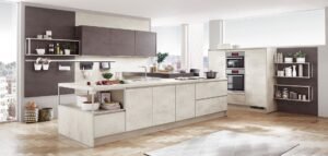 Cocina de diseño contemporáneo en Sevilla con acabados efecto cemento, isla funcional y zona de cocción integrada.