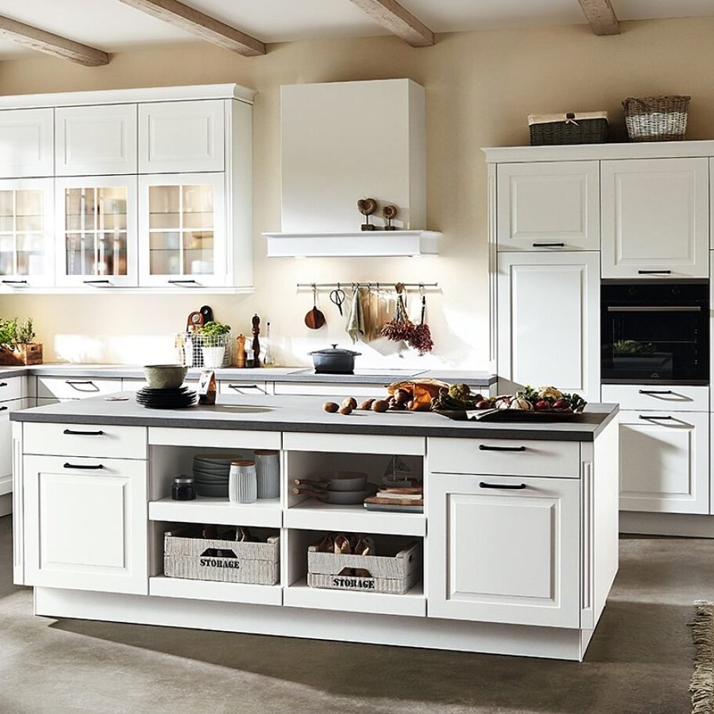 Cocina rústica en Sevilla con muebles blancos, isla con baldas abiertas y detalles decorativos clásicos, ideal para hogares con encanto tradicional.