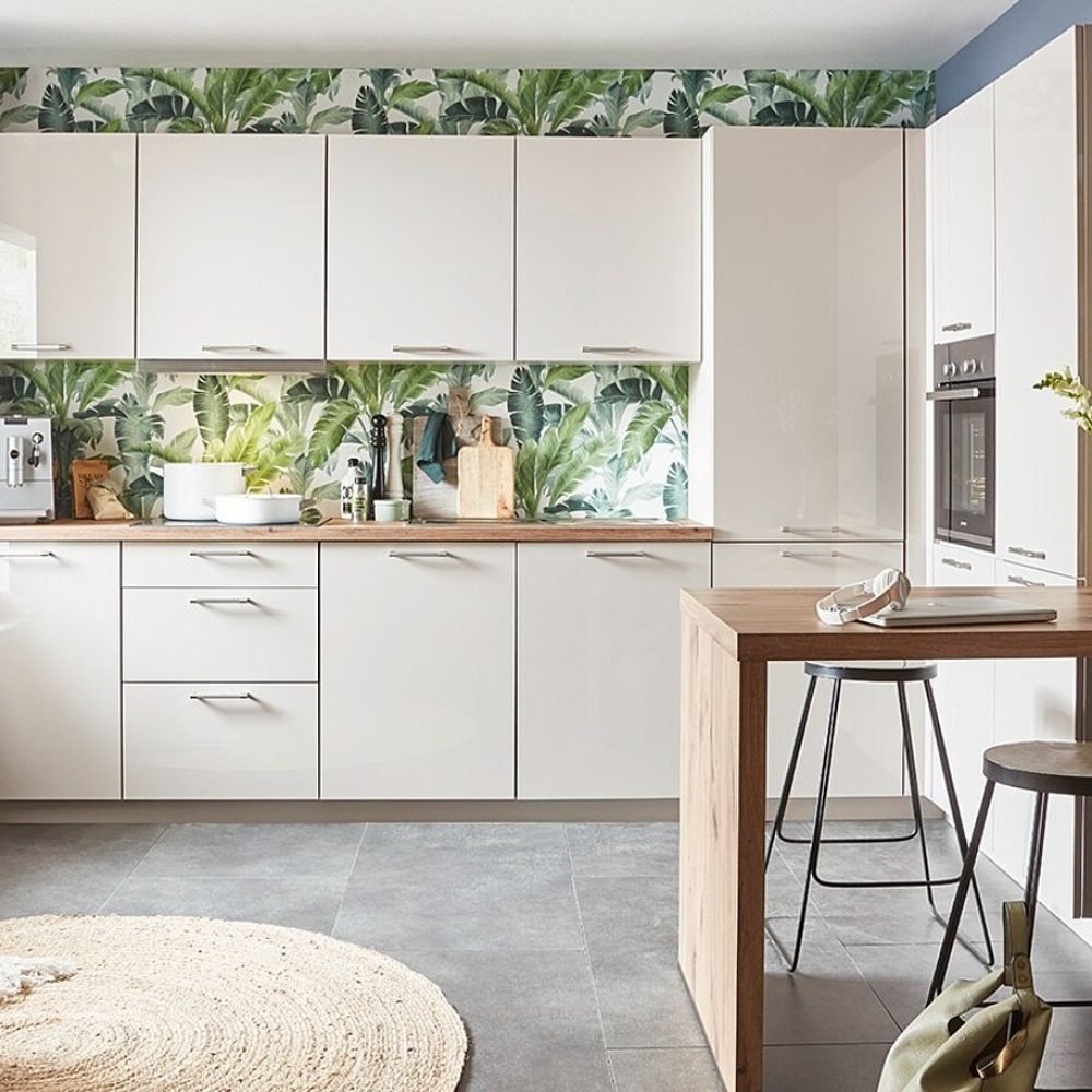 Cocina pequeña en Sevilla con muebles blancos, barra de madera y diseño vegetal, ideal para espacios reducidos con estilo actual.