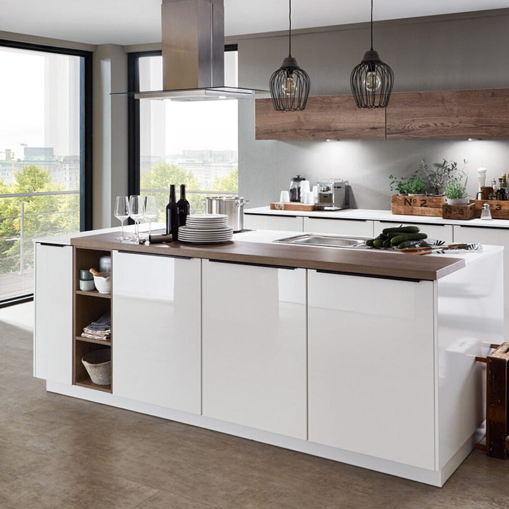 diseño de cocinas a medida en Sevilla Cocina a medida en Sevilla con isla blanca, columnas altas y diseño moderno con iluminación natural y acabados personalizados.
