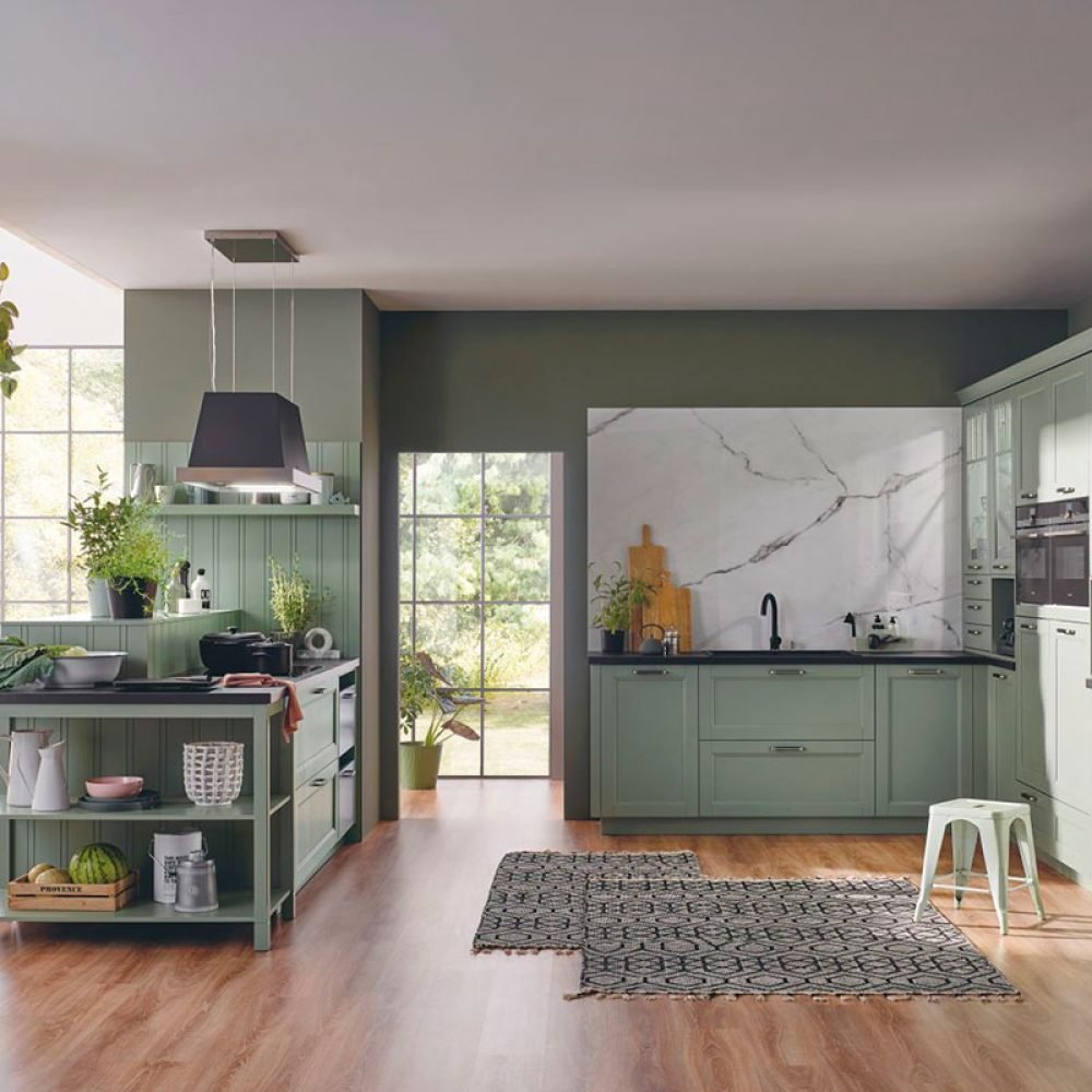 Cocina rústica en Sevilla con muebles verdes, isla central funcional y revestimiento hidráulico, ideal para casas con encanto tradicional.